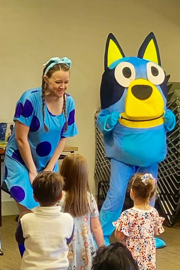 Bluey character and storyteller greeting young children at a story time event in Utah
